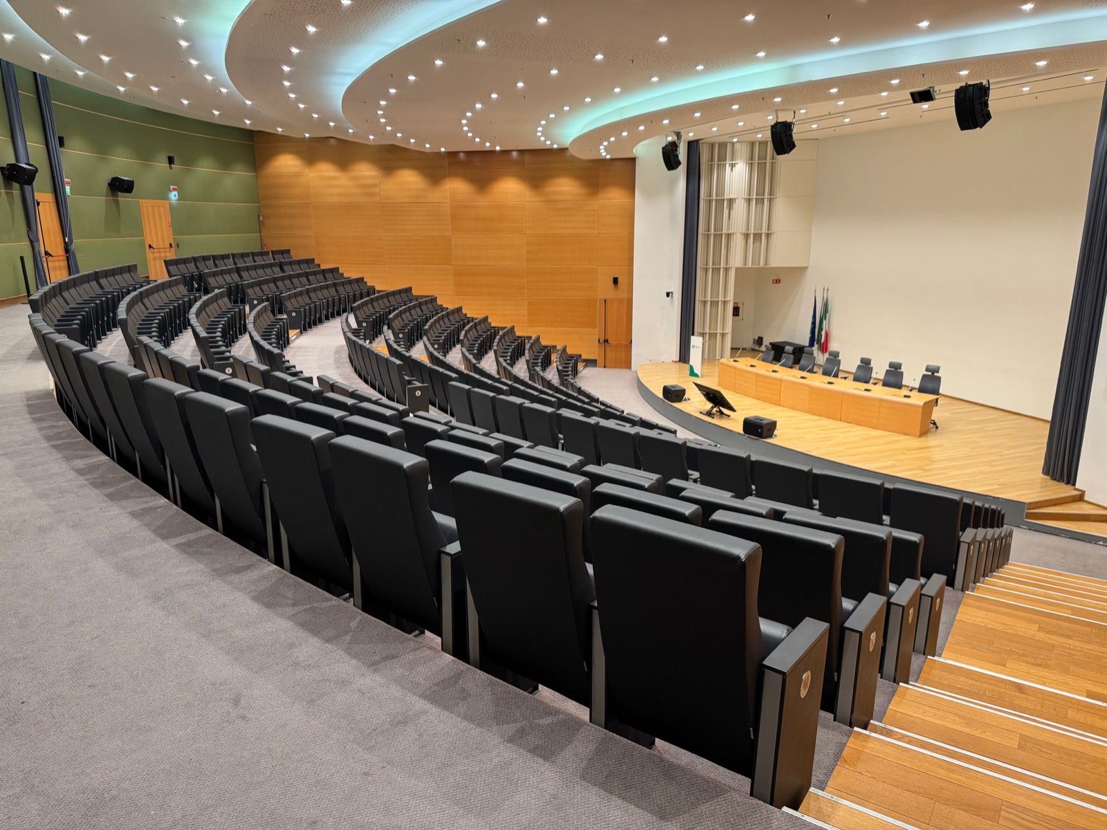 A conference hall set with rows of seats facing a stage
